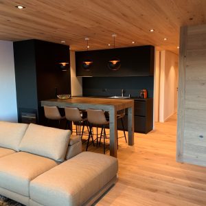 Un salon avec un canapé et une cuisine en arrière-plan