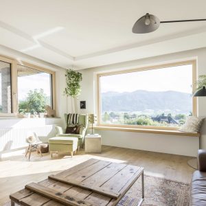 Il y a une grande fenêtre dans le salon avec vue sur les montagnes.