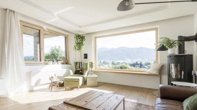 Il y a une grande fenêtre dans le salon avec vue sur les montagnes.